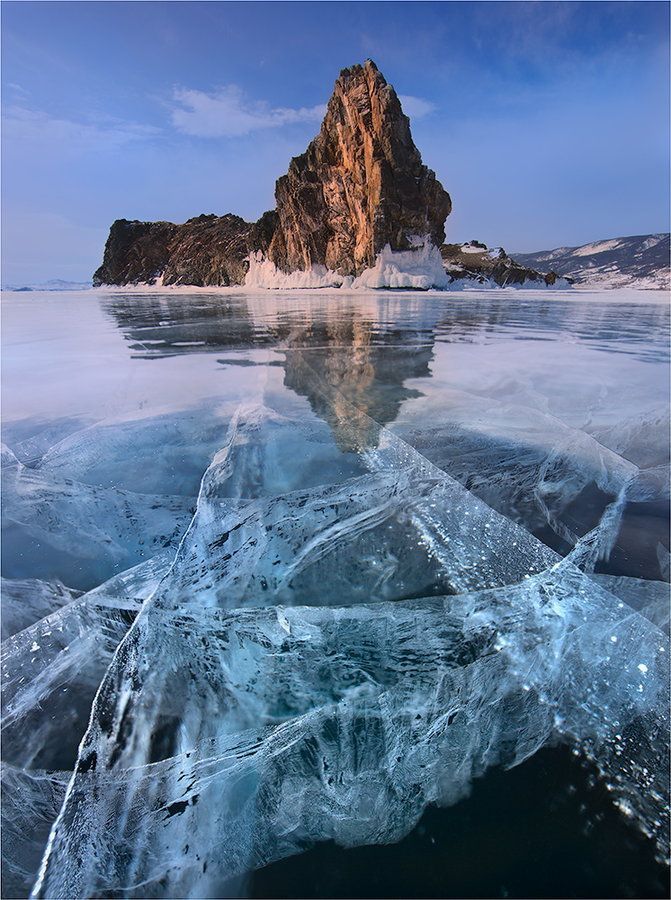 an ice floet floating on top of water next to a large rock formation