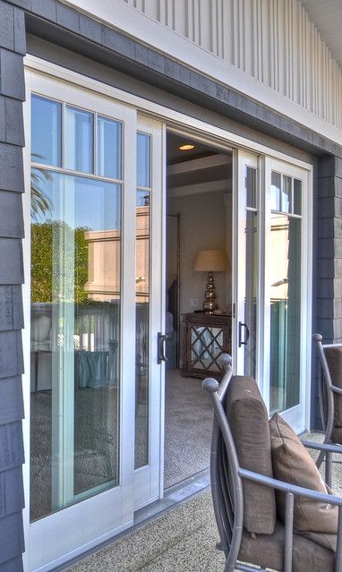 an outside patio with chairs and sliding glass doors that lead into the living room area