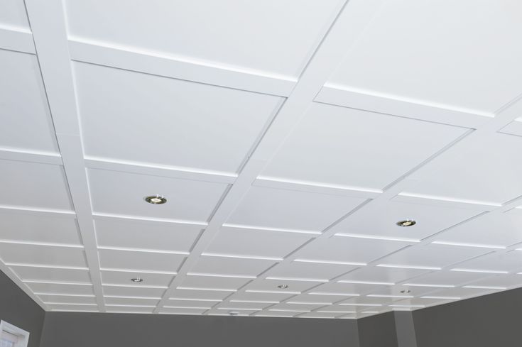 an empty room with white ceiling tiles on the ceiling