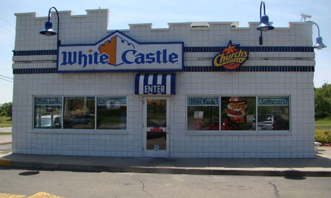 a white castle restaurant with cars parked in front