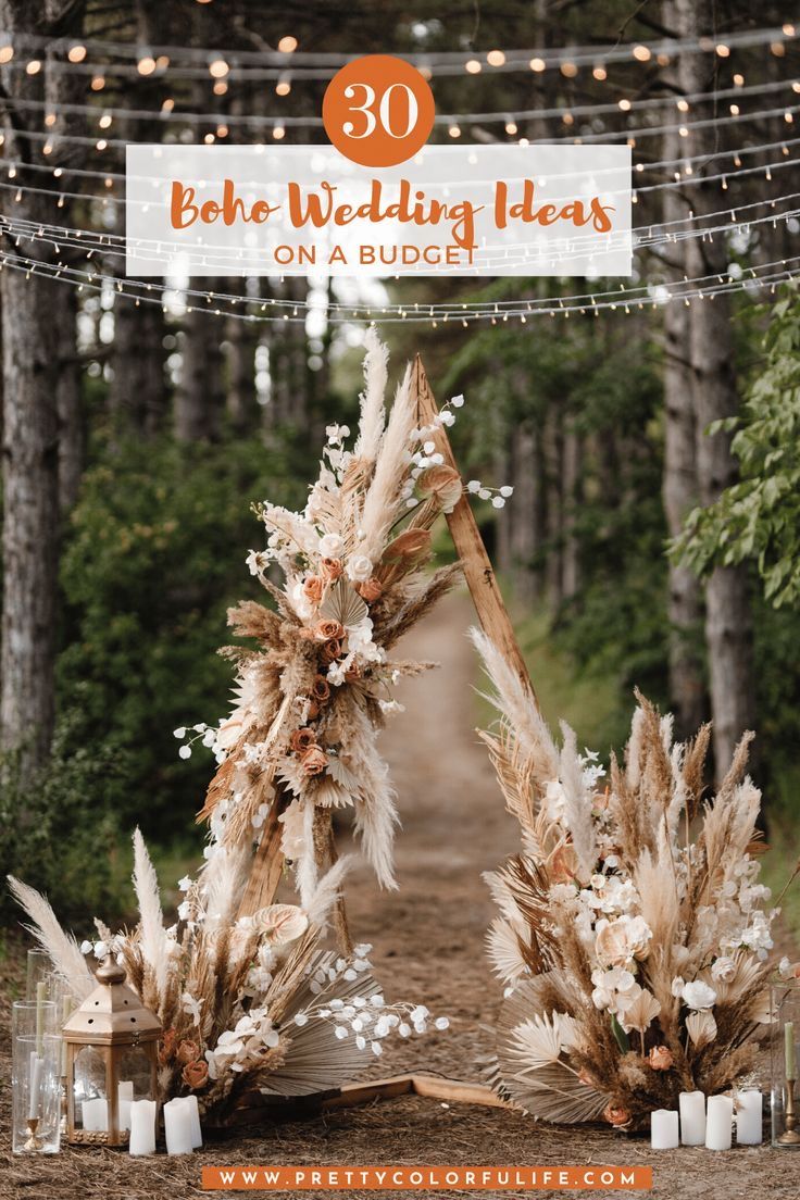 a wedding arch with candles and flowers on it in the middle of a dirt road