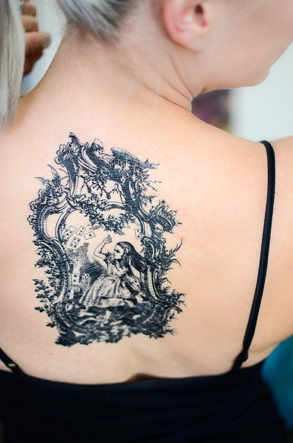 the back of a woman's shoulder with a tattoo on it