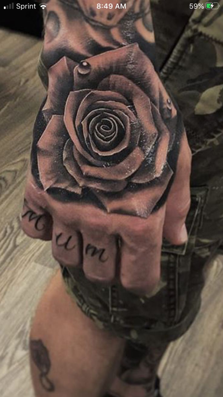 a person's hand with a rose tattooed on it