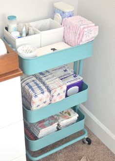 a blue shelf filled with lots of diapers next to a bathroom sink and toilet