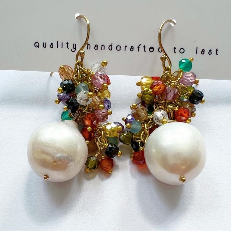 A faceted semi-precious baroque pearl drop adorned with mini semi-precious stones dangles from 14k gold-filled ear wire. Approximately 1.5”in length Also available in smaller baroque pearl 1” in length. I can do straight down, long festivals, or we can do a different arrangement with the festival rainbow stones dangling down the pearl. Let us know in the notes section upon ordering. *Hypoallergenic and quality handcrafted to last! Gold Pearl Earrings With Natural Stones, Handmade Briolette Pearl Earrings, Teardrop Pearl Earrings With Natural Stones, Natural Stone Dangle Pearl Earrings, Pearl Briolette Earrings, Gold Briolette Pearl Gemstone Earrings, White Pearl Earrings With Natural Stones, Briolette Pearl Earrings, Festival Earrings