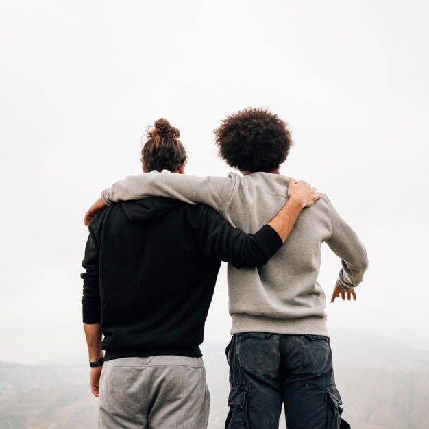 two people standing on top of a mountain