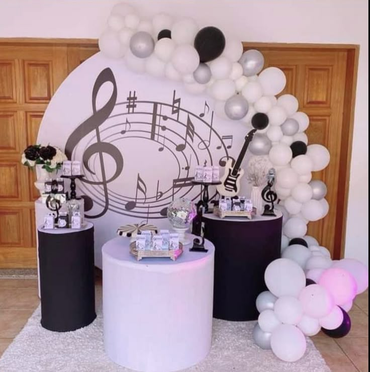 balloons and music notes are on display in front of a backdrop for an event or party