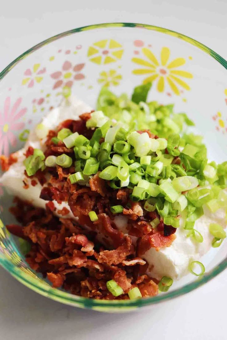 a bowl filled with meat and vegetables on top of a table