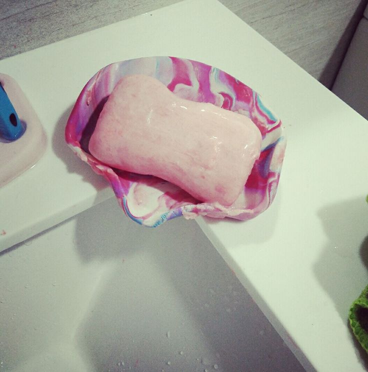 a pink and white bowl filled with food on top of a counter next to a toothbrush