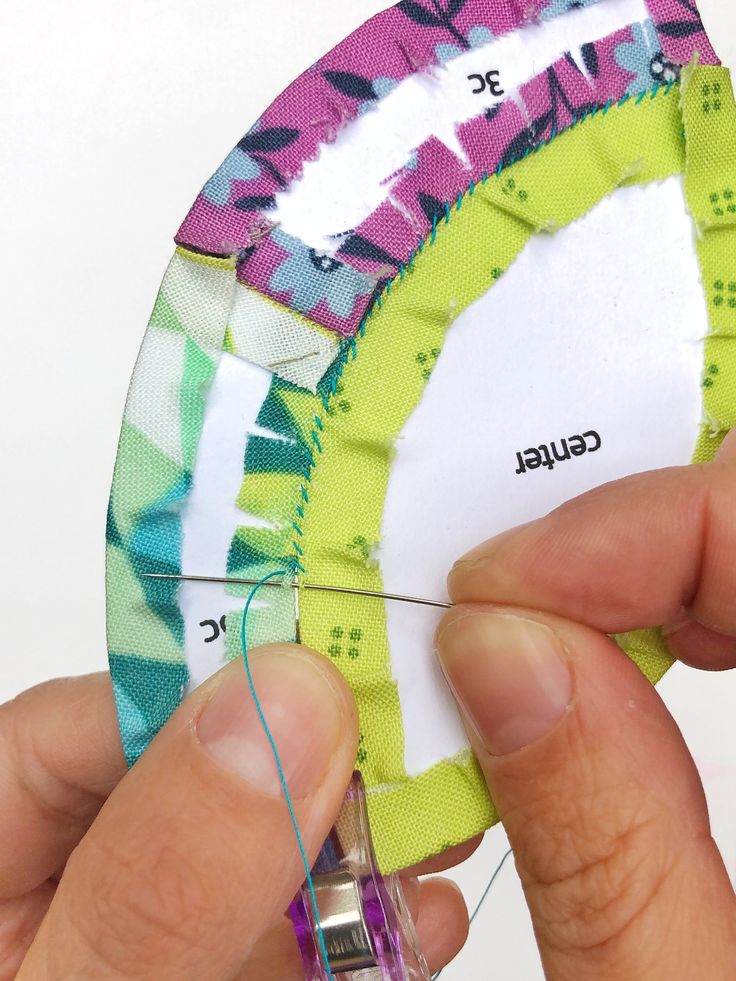 someone is stitching the side of a piece of fabric with scissors and thread on it