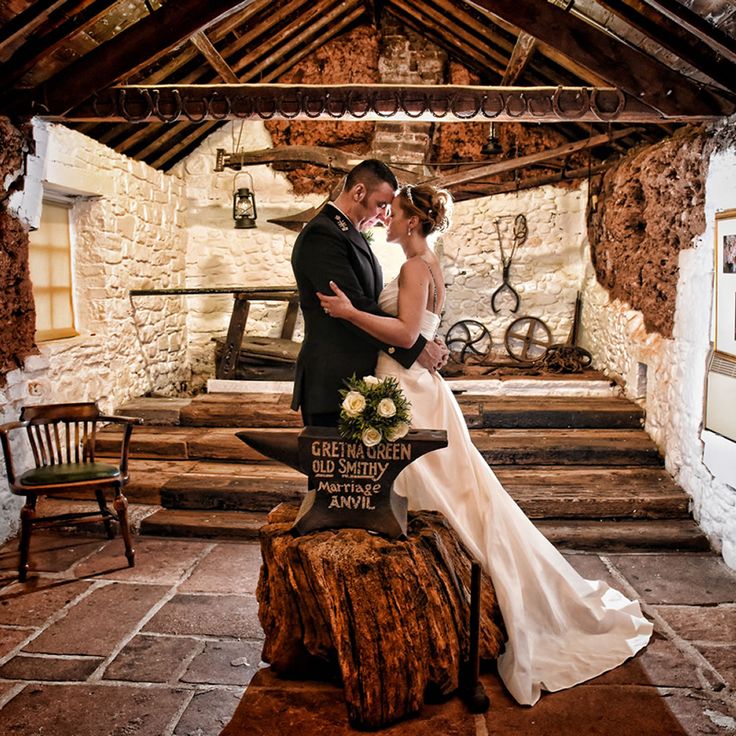 a bride and groom posing for a photo in an old stone building with wooden stairs