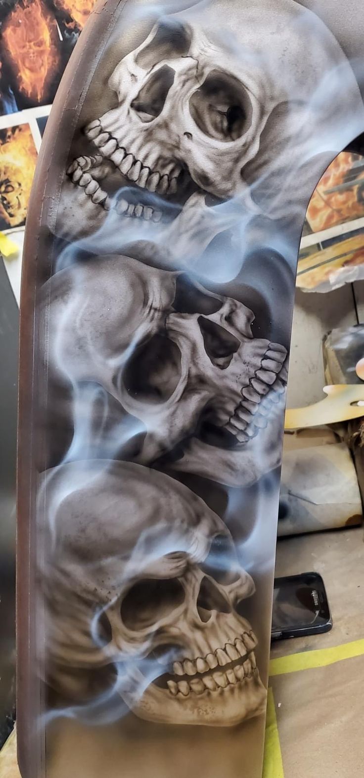 a skateboard with two skulls on it and flames coming out of the bottom half