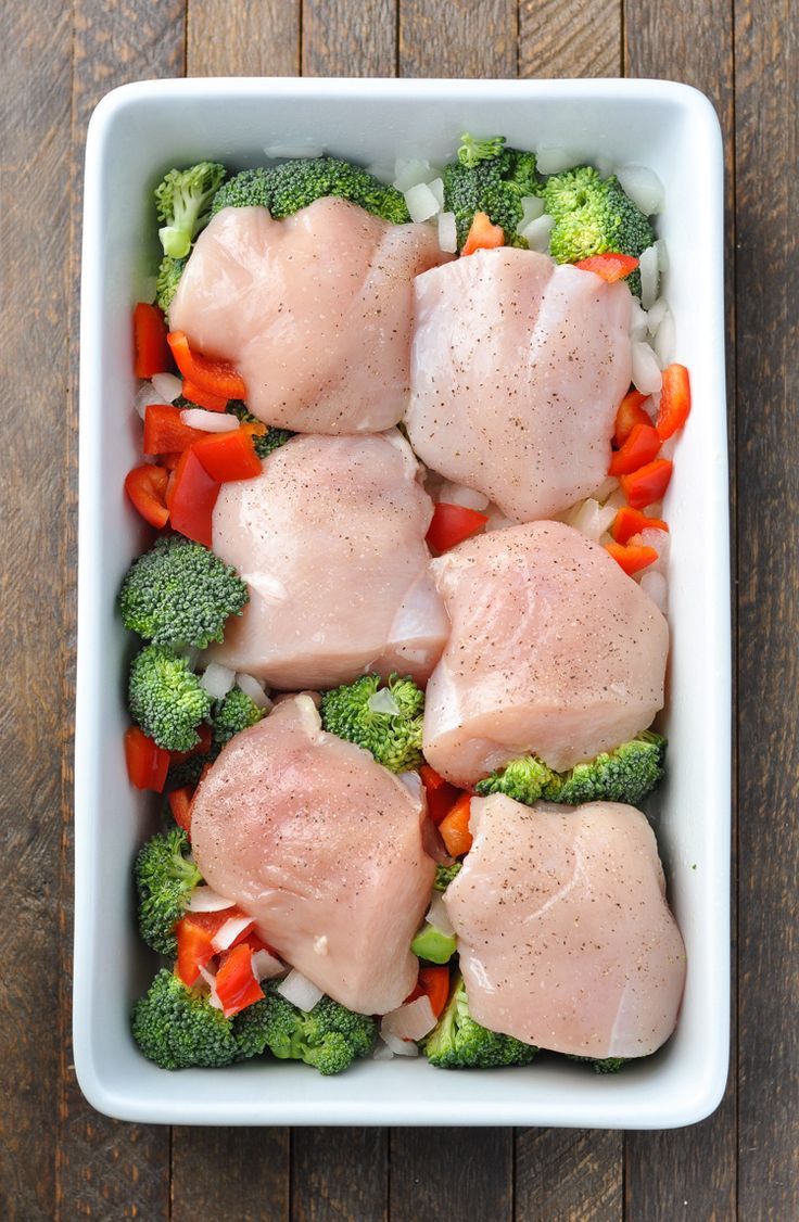 chicken and broccoli in a casserole dish on a wooden table top