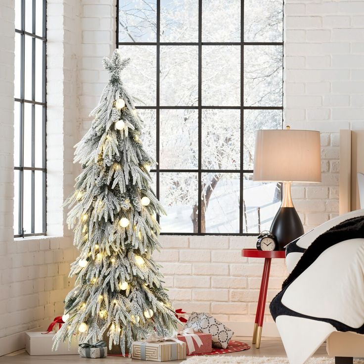 a decorated christmas tree in front of a window