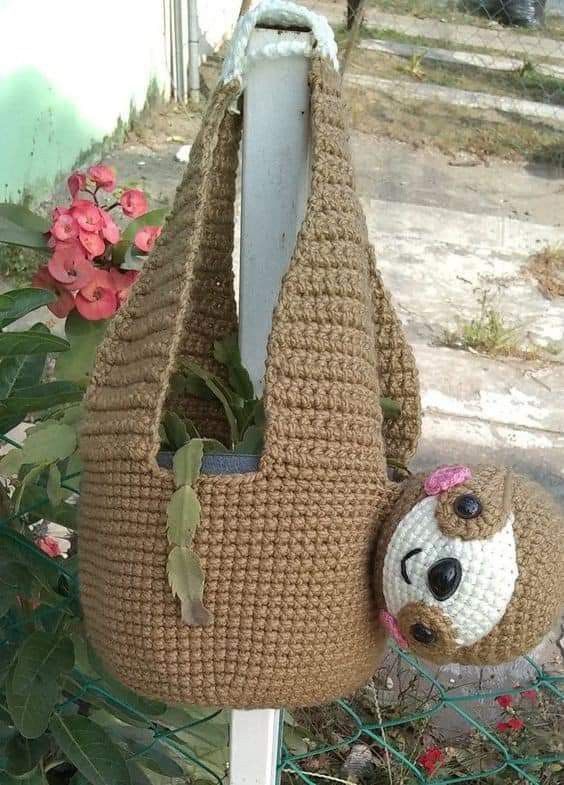 a crocheted bag with a stuffed animal hanging from it's front end