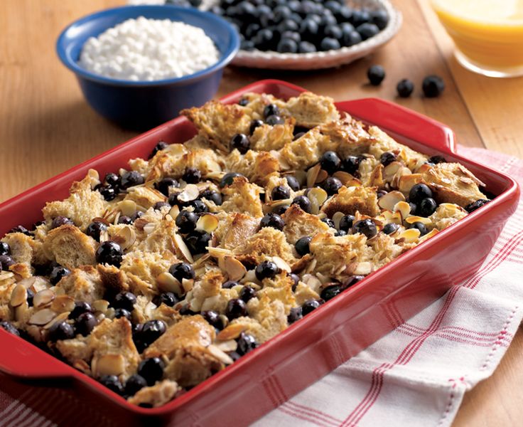 a casserole dish with blueberries and rice in it on a wooden table