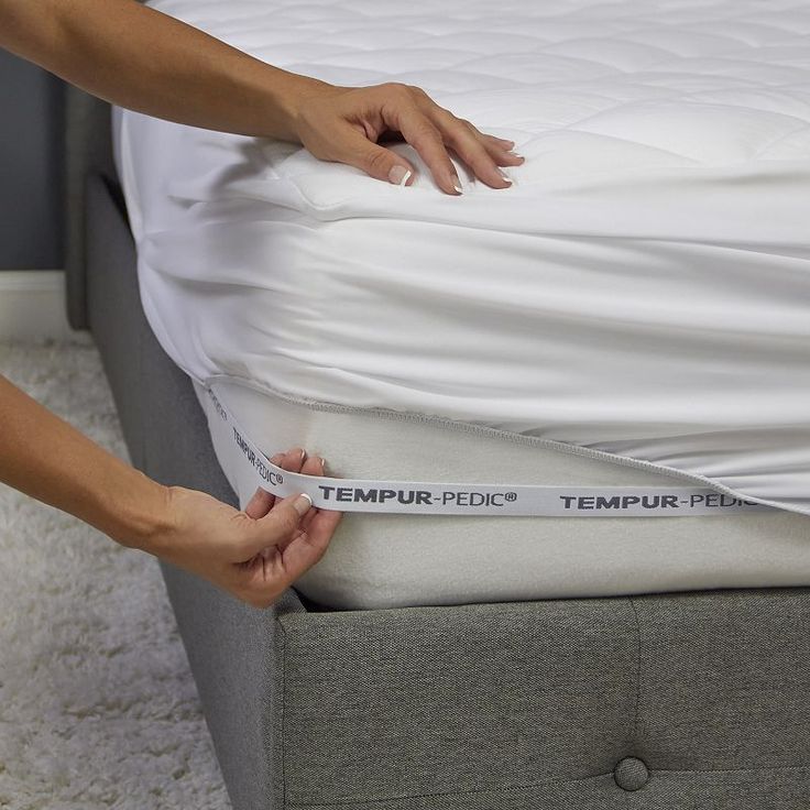 a woman is placing the mattress on top of her bed