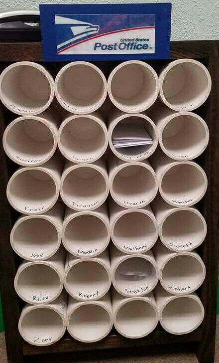 a stack of white cups sitting on top of a wooden shelf next to a post office sign