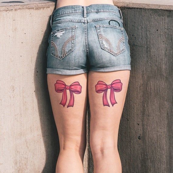 a woman's legs with pink bows on them and an arrow in the middle