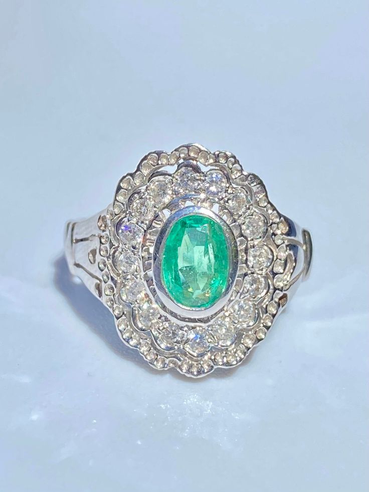 Art Deco inspired Emerald ring of 0.65 carats. Emerald is oval brilliant cut and mounted in 14k white gold setting. Intricate floral ring design mounts a vibrant light green Colombian Emerald center stone. ✔ Gold Karat: 14K ✔ Emerald Weight: 0.65 carats ✔ Emerald Origin: Colombia ✔ Emerald Cut: Oval ✔ Diamond Weight: 0.20 carats total ✔ Diamond Color: H-I ✔ Diamond Clarity: SI1 ✔ Ring Weight: 4.90 grams ✔ Certificate of appraisal included upon request SHIPPING TIMES USA: 3-14 business days (USPS Oval Emerald Ring In 14k White Gold, Dazzling Oval Emerald Ring In Platinum, Gia Certified Oval White Gold Diamond Ring, Dazzling Oval Gia Certified Rings, Oval Platinum Diamond Ring Gia Certified, Exquisite Oval Emerald Ring, Dazzling Oval Emerald Gemstone Ring, Gia Certified Oval Diamond Ring Fine Jewelry, Gia Certified Oval Diamond Ring In Diamond White