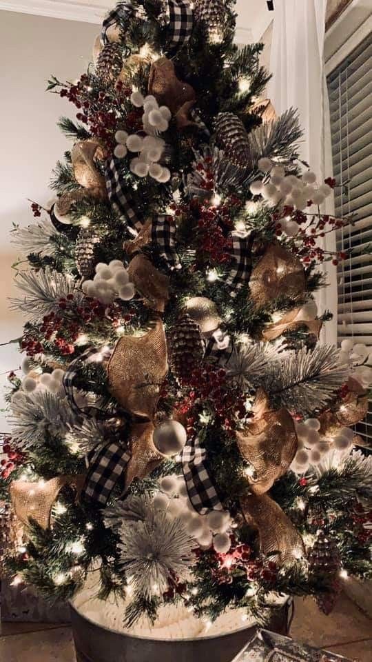 a christmas tree decorated with gold, silver and red ornaments in a metal pail