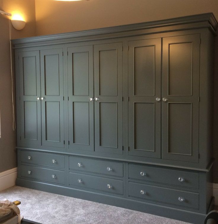 a large green armoire in a room with carpeted flooring and white walls