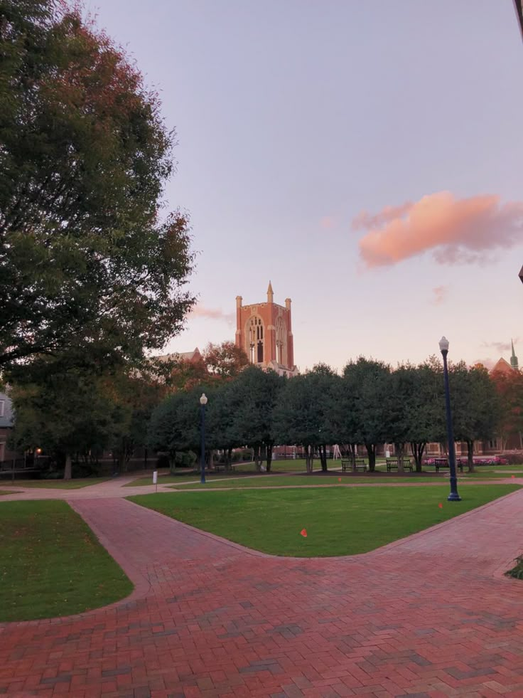 a brick walkway in front of a building with a clock tower on the other side