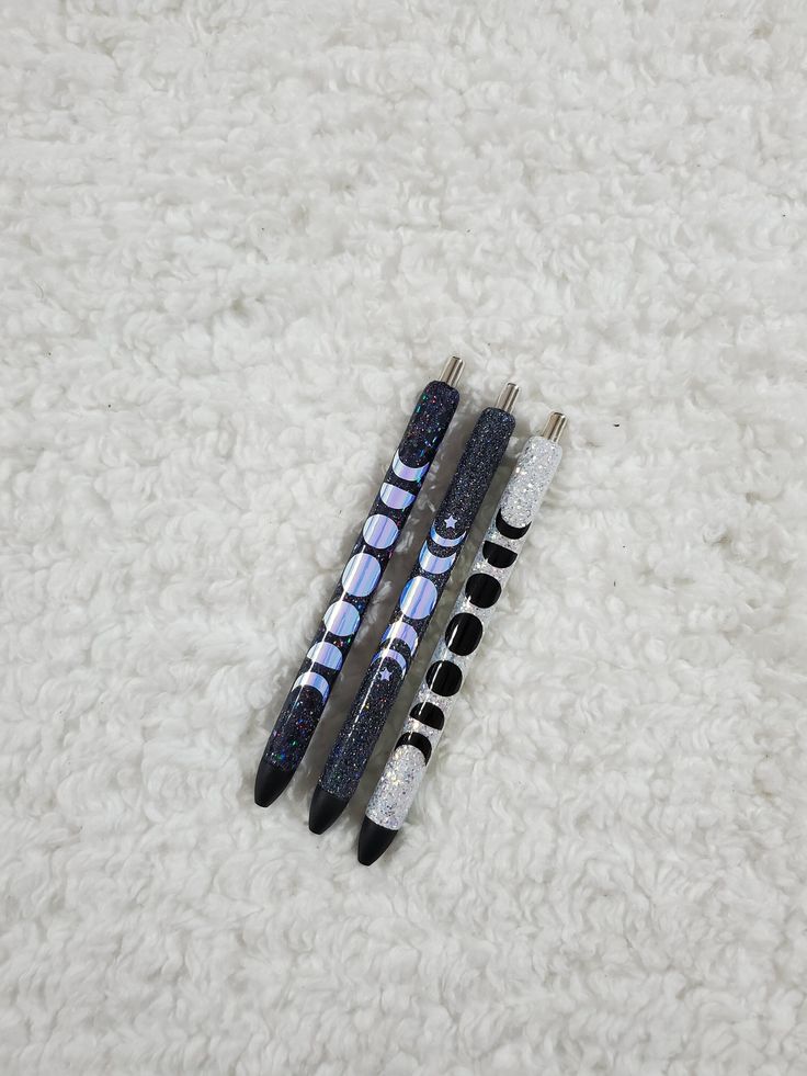 three pens sitting on top of a white carpet