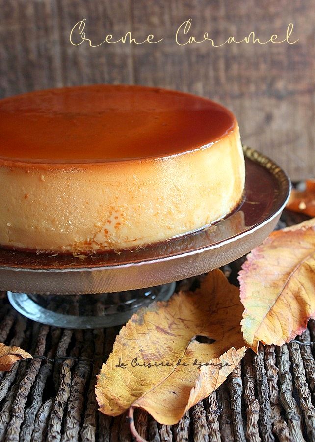 a cheesecake sitting on top of a cake plate with leaves around it and the words, creme caramel