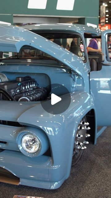 an old blue truck is on display at a car show