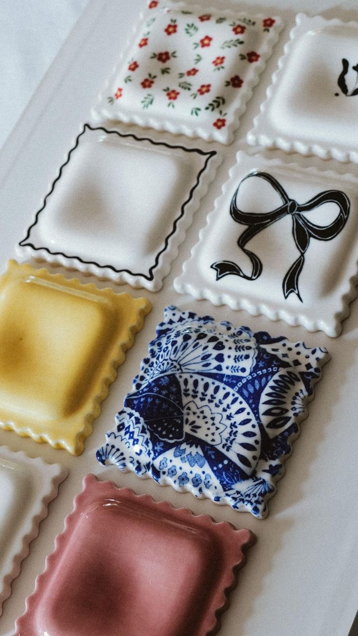 a white plate topped with lots of different colored trays covered in frosted icing