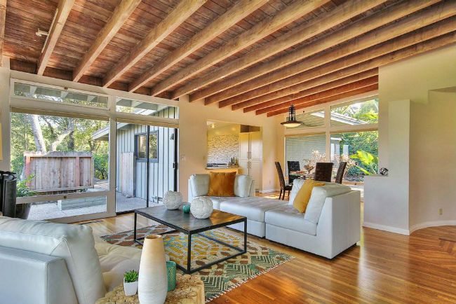 a living room filled with white furniture and lots of wood flooring on top of a hard wood floor