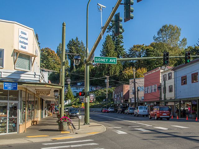 an intersection with several buildings and cars on the street in front of them, including two stores