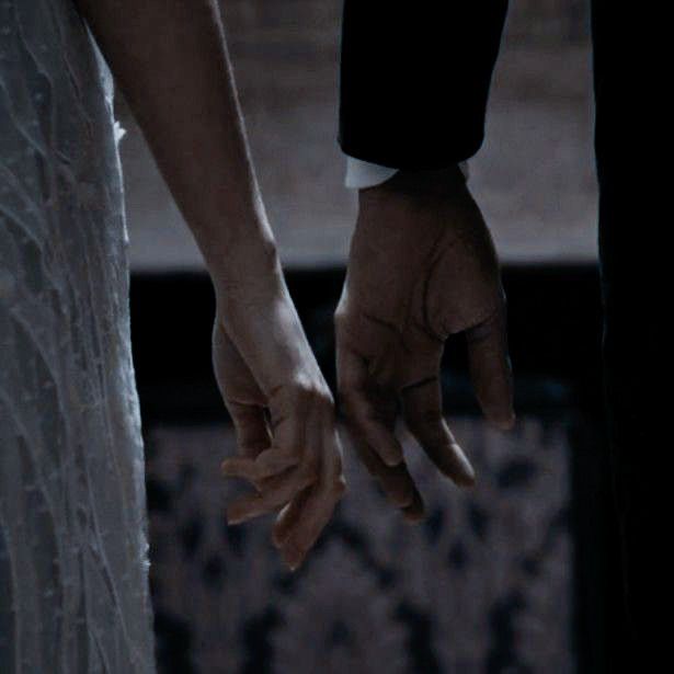 two hands holding each other in the dark