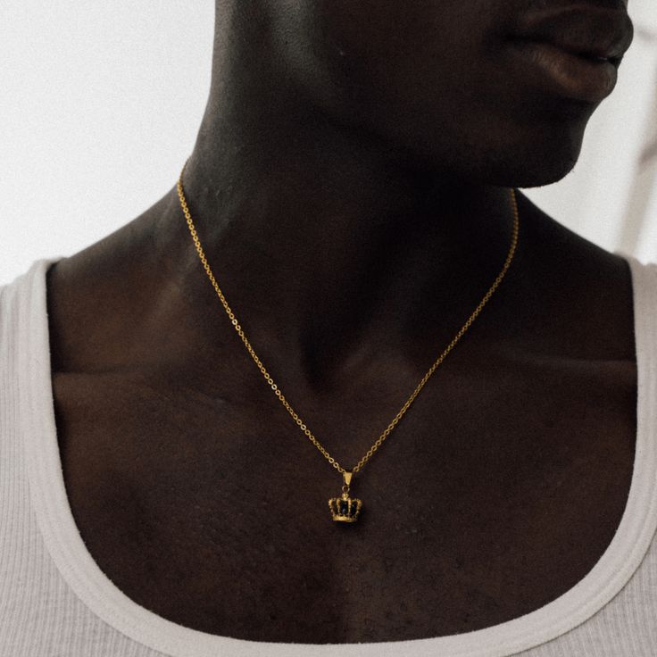 Your kingdom. Your rules. A solid onyx stone sits encased within an intricate 18K Gold crown, marking it as one of our most detailed and must-have pendants to date. This piece boasts ultra-durable, scratch-resistant plating and hangs regally upon a 3mm Gold Link Chain - a true standout of the King's Collection. For a seamless look, effortlessly stack it alongside the 18K Gold Crown Band Ring and any Gold Bracelet of your choice. Included: Full Lifetime Warranty ✓ 18K Gold & 316L Stainless Steel✓ Regal Gold Jewelry Gift, Regal Gold Necklace For Gift, Royal Gold Jewelry For Formal Occasions, Gold Crown Men, Luxury Crown Design Jewelry Gift, Royal Gold Jewelry As A Gift, Royal Gold Jewelry Gift, Royal Gold Jewelry For Gift, Classic Crown Jewelry For Gift