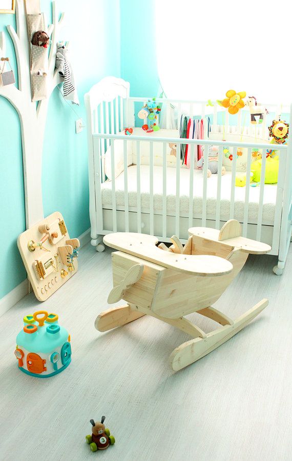 a baby's room with blue walls and white furniture