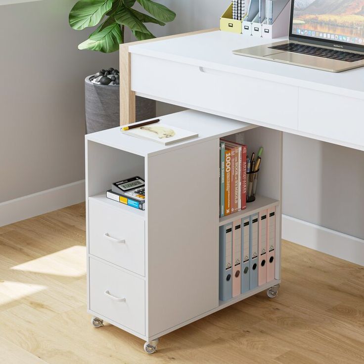 a white computer desk with a laptop on top of it and drawers underneath the desk