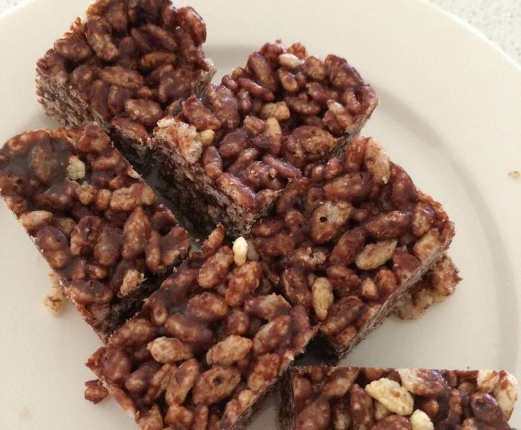 three pieces of brownie on a white plate with walnuts in the middle and one piece cut out