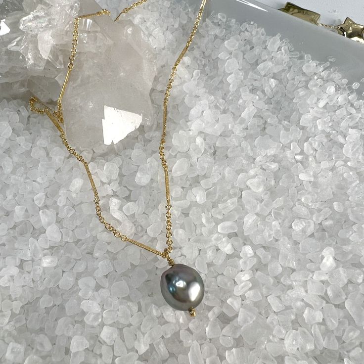 This beautiful necklace features one lustrous 10mm Tahitian Pearl Pendant, dangling from a sparkly bar & link chain finished off with 2" extender and a dangle of gold beads.The Tahitian Pearl is lighter in color, but still have gorgeous luster with shades of gray and beautiful shine. Paired with the bar & link chain, it is a stunning combination!Each pearl is one of a kind with variations in color, shape & luster. This makes each piece of jewelry truly unique! All pearls are the highest quality Gold Tahitian Pearl Pendant Necklace, Gold Necklace With Tahitian Pearl Pendant, Gold Tahitian Pearl Necklace With Pearl Charm, Gold Tahitian Pearl Necklace With Pearl Pendant, Tahitian Pearl Pendant, Shades Of Gray, Link Chain Necklace, Tahitian Pearls, Beautiful Necklace