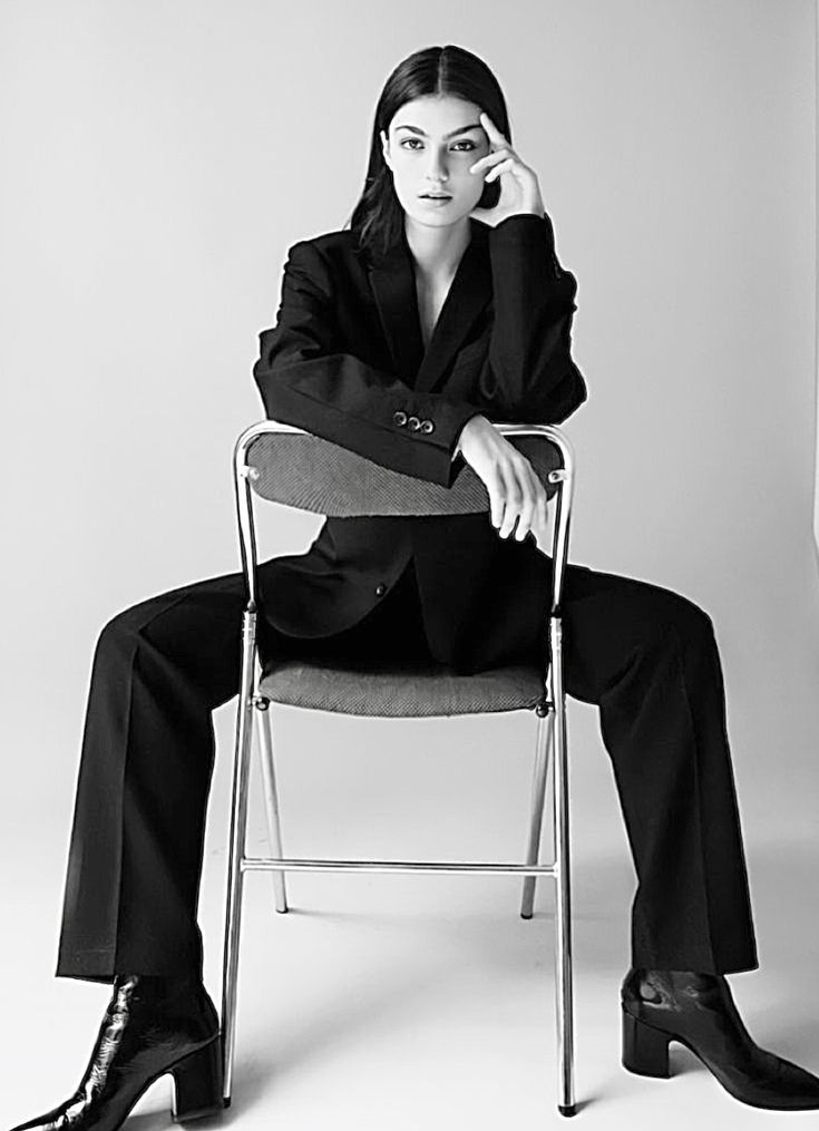 a woman sitting in a chair with her legs crossed