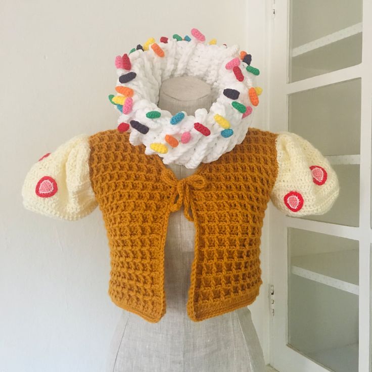 a crocheted vest with candy sprinkles on the collar and sleeves