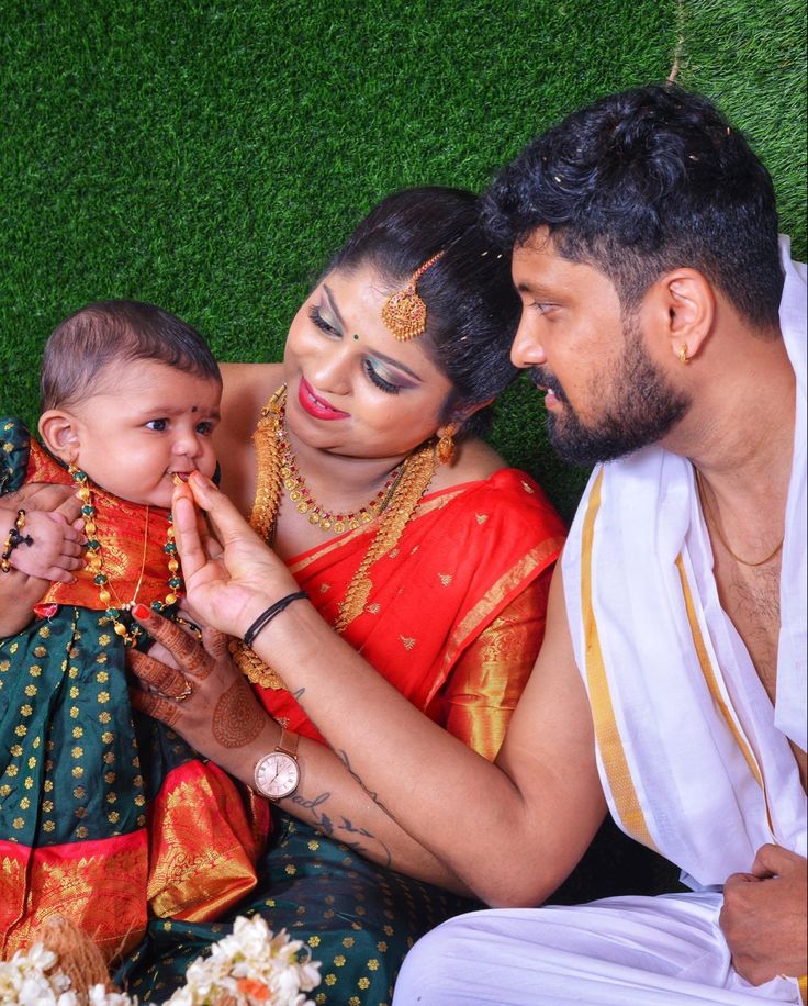 a man and woman sitting next to a baby