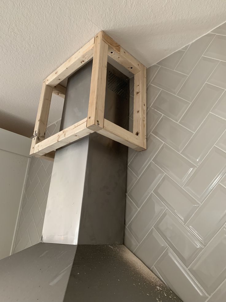 a stove top oven sitting inside of a kitchen next to a white tiled wall and ceiling