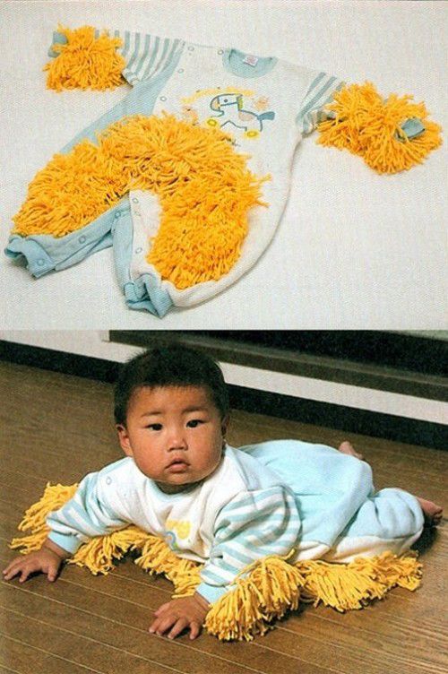 a baby laying on the floor next to an infant's body covered in yellow yarn