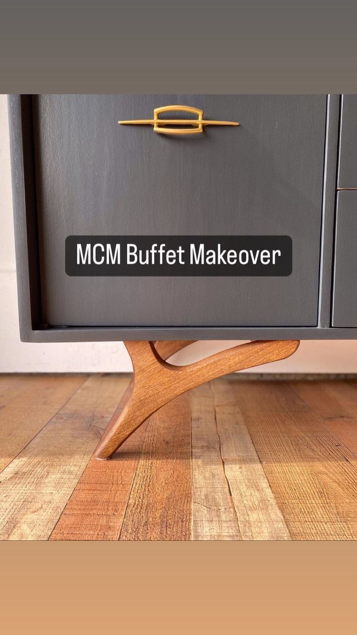 the words mcm buffet makeover are written in black on a gray cabinet with wooden legs