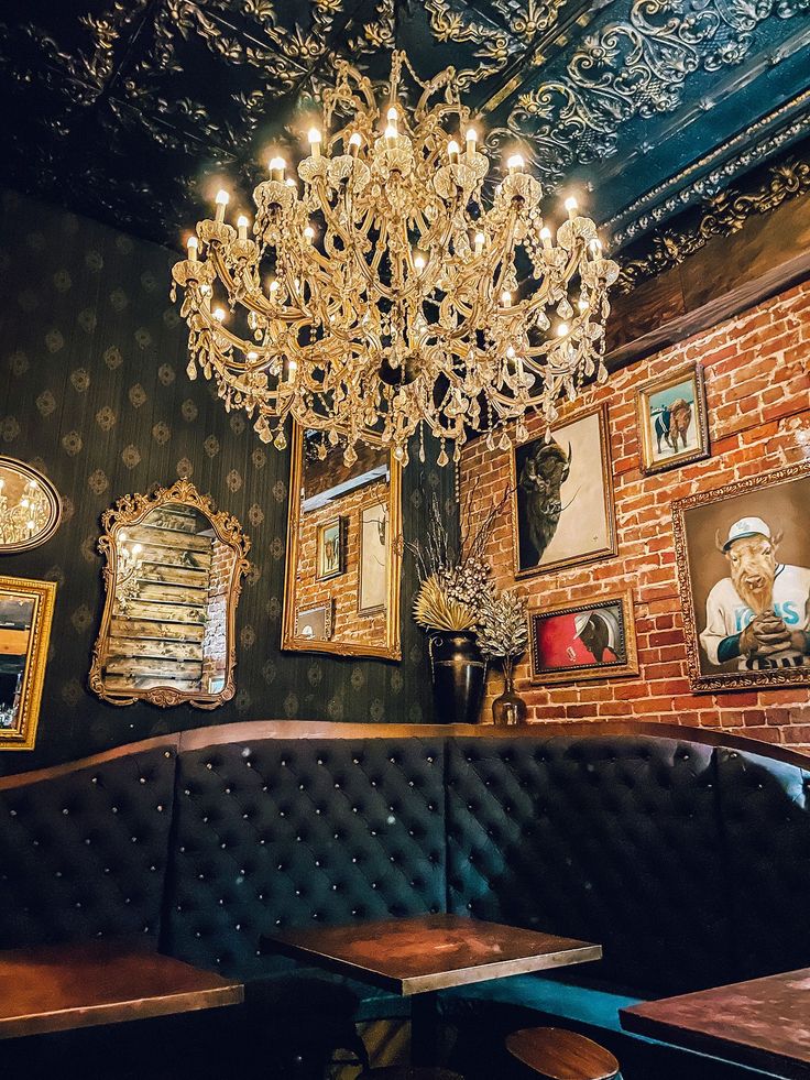 a chandelier hanging from the ceiling in a restaurant with pictures on the wall