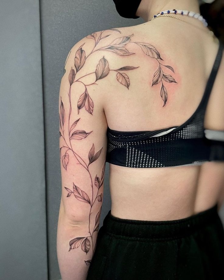 the back of a woman's shoulder with leaves and vines on her left arm