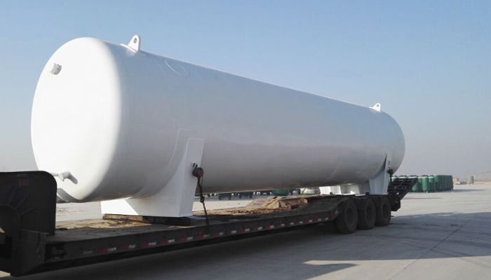 a large white tank on the back of a flatbed truck