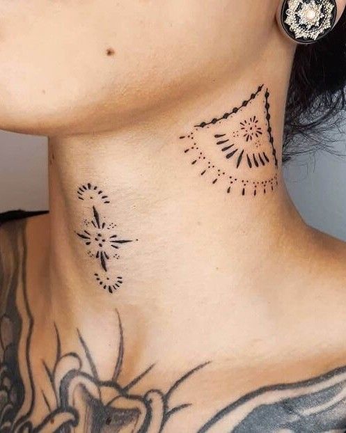 a woman's neck with tattoos on it