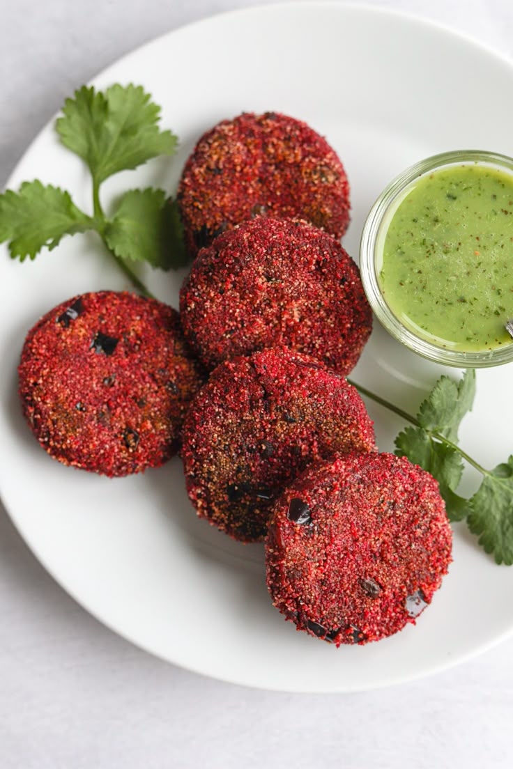 some food on a white plate with a small green dip in the middle next to it